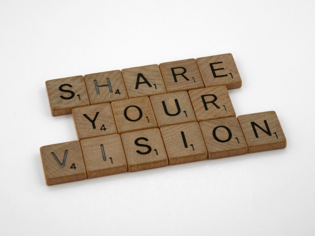 scrabble tiles that spell "share your vision"