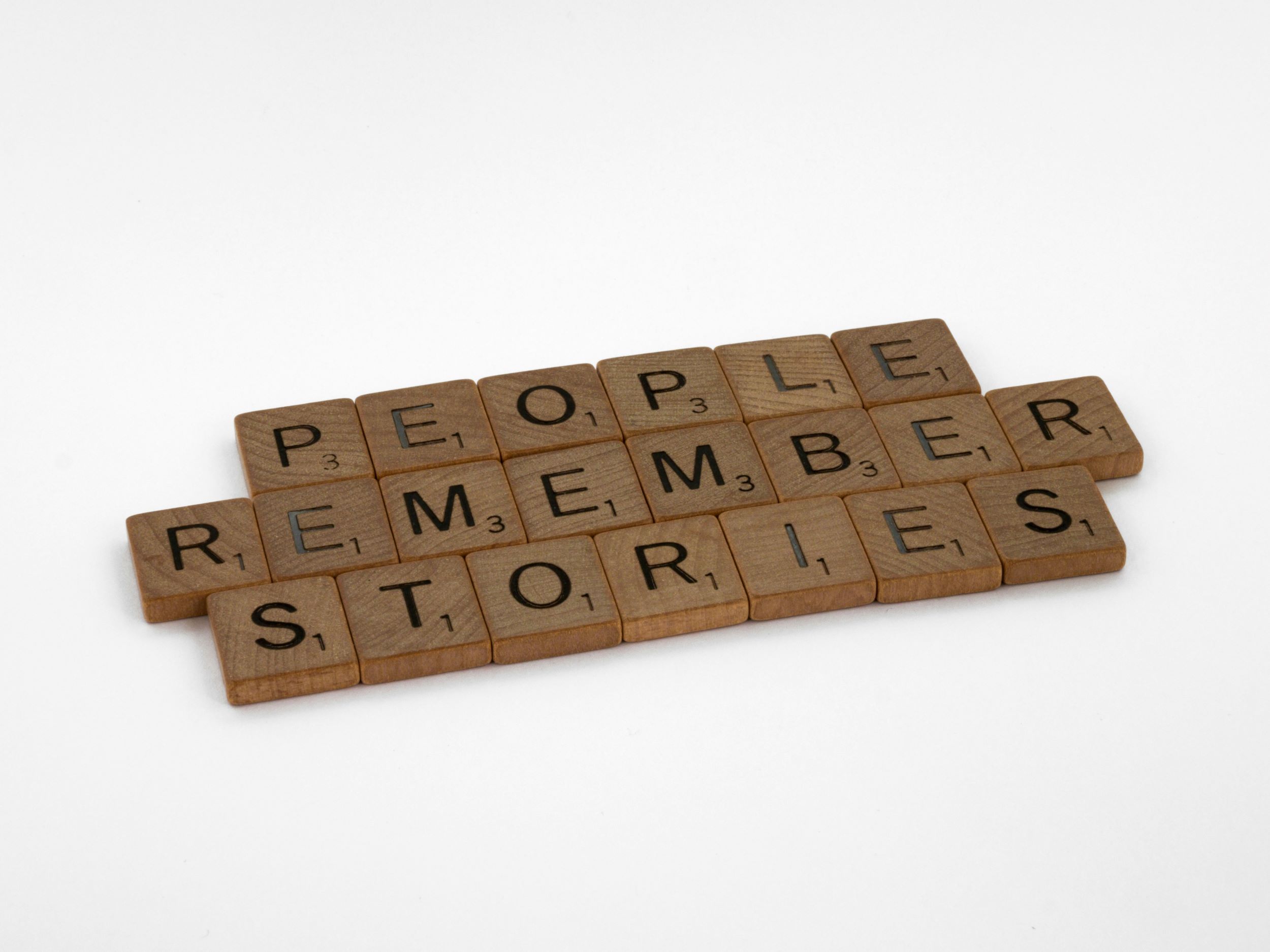 Scrabble tiles that spell "People remember stories"