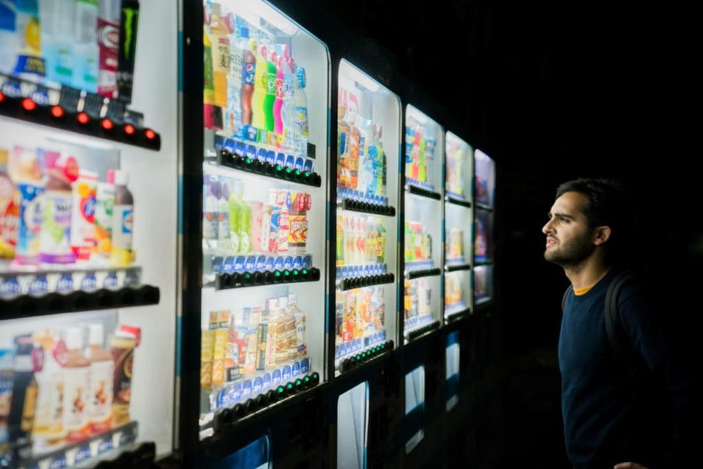 man considering vending machine choices