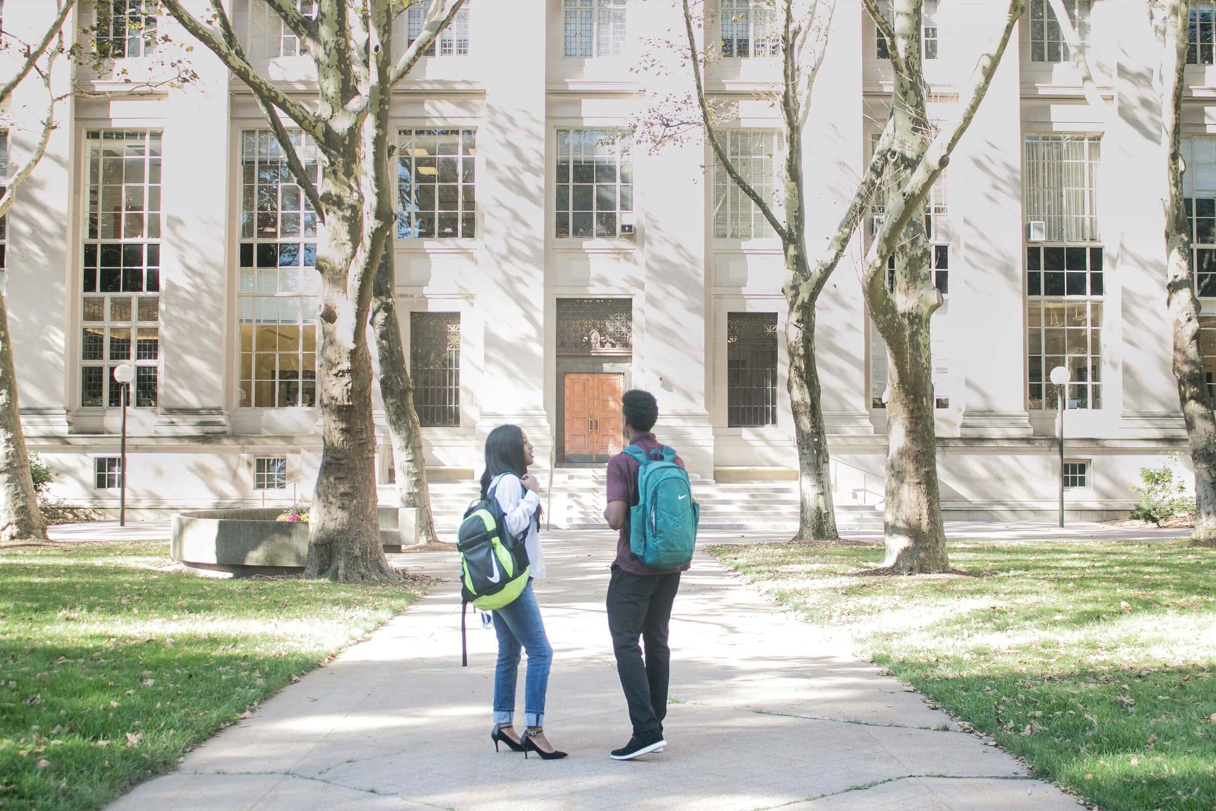 two college students in front of campus building