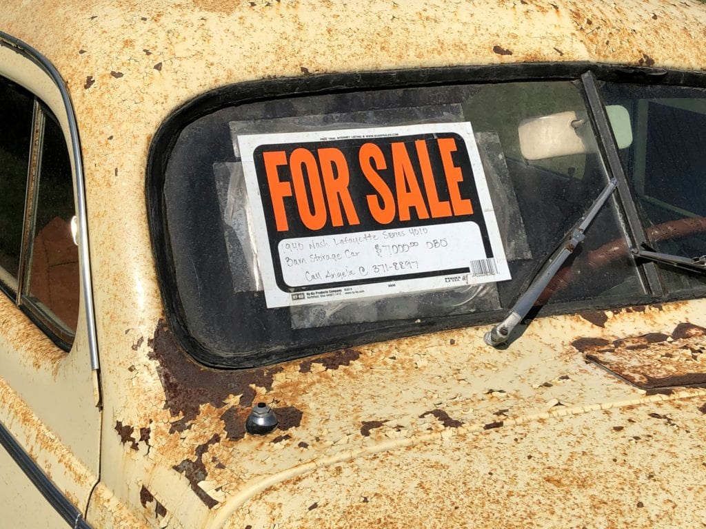 old car with for sale sign in window