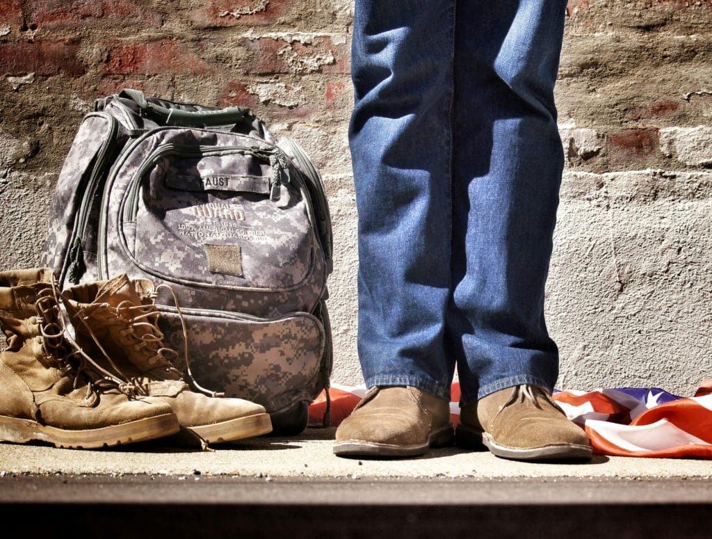 veteran with boots and US national guard backpack