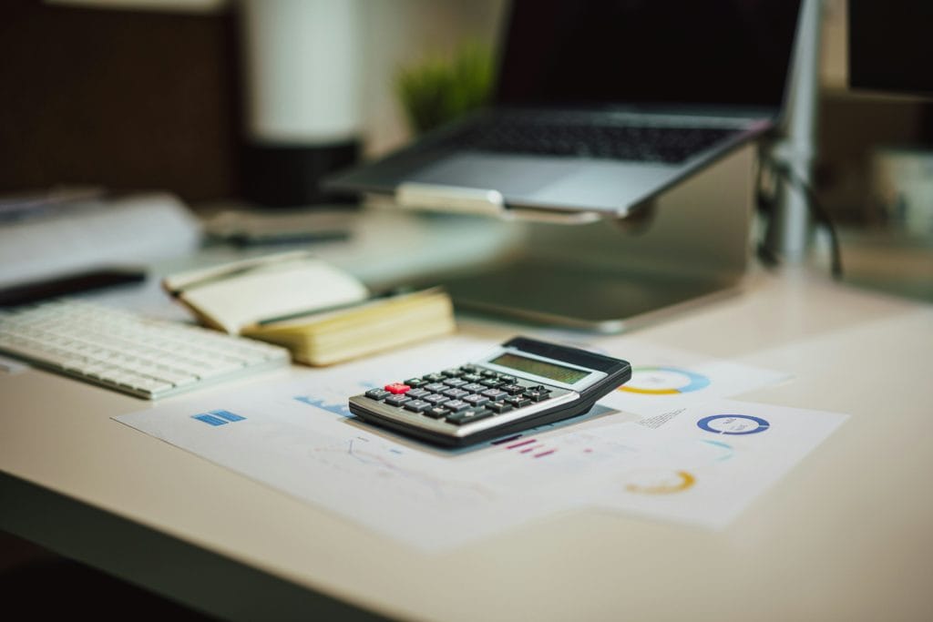 calculator and report papers on desk