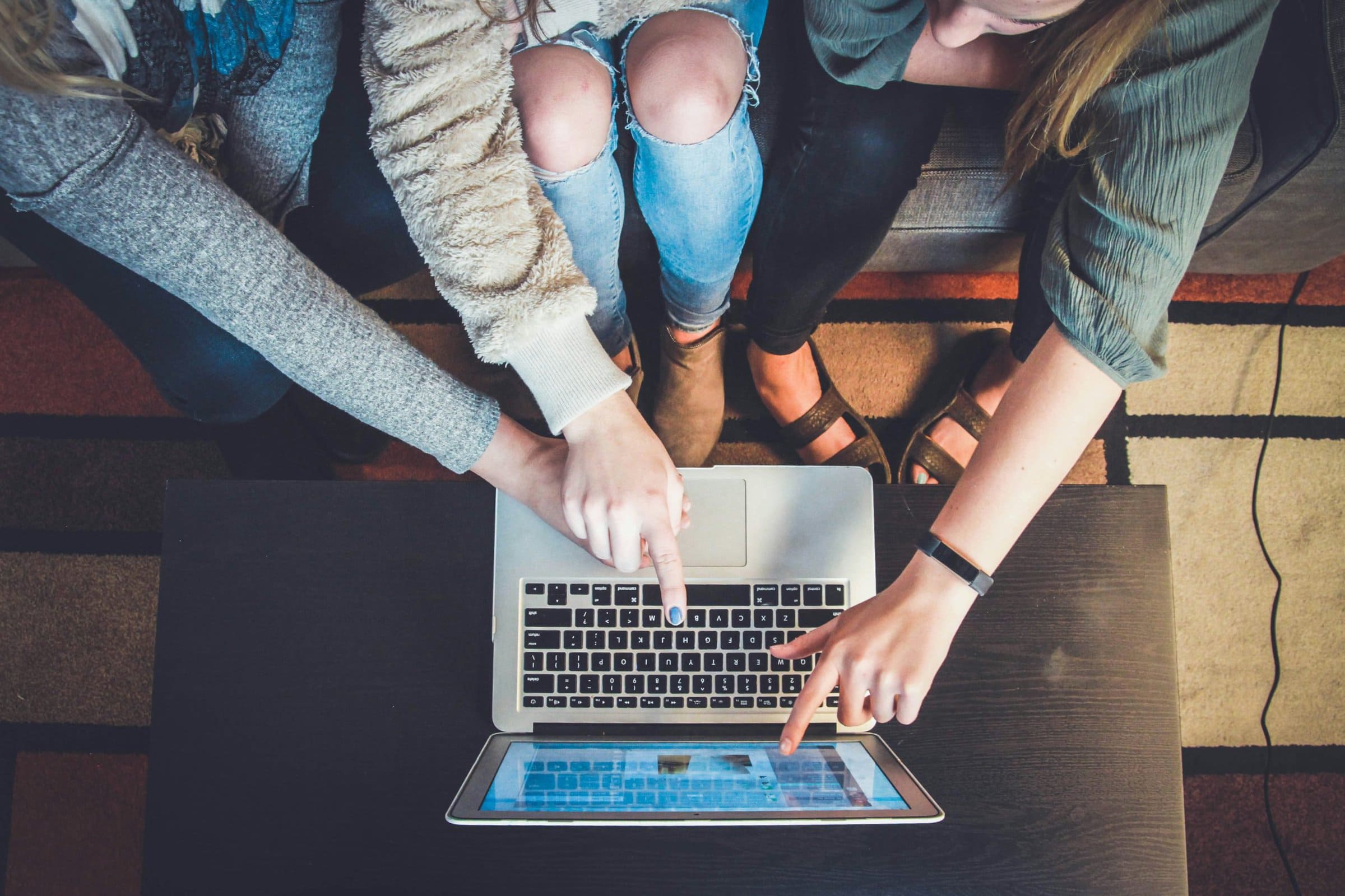 several people looking at one laptop