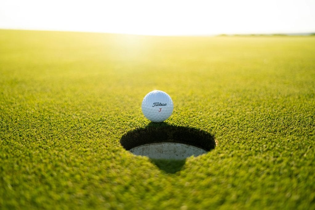 golf ball on edge of hole