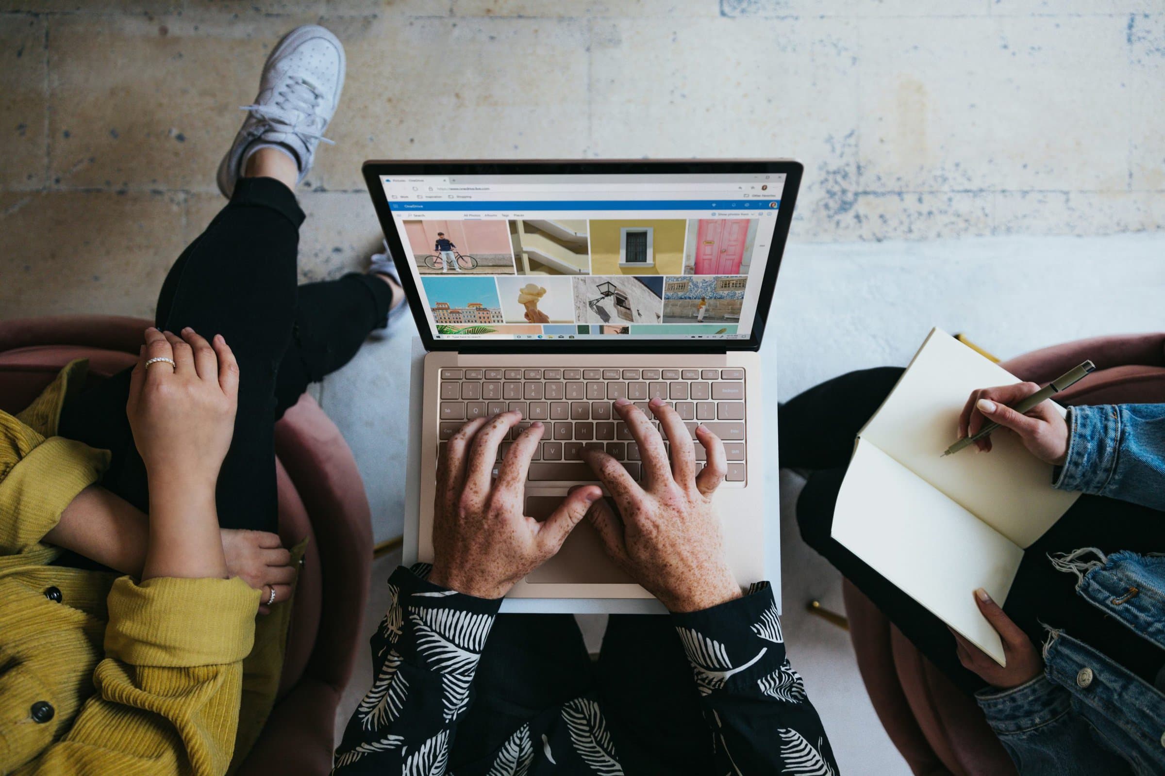 three people looking at laptop